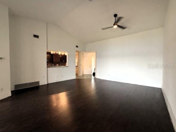 spare room featuring dark hardwood / wood-style flooring, high vaulted ceiling, and ceiling fan