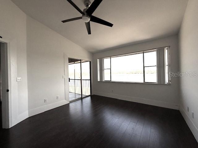 spare room with dark wood-type flooring, ceiling fan, and lofted ceiling