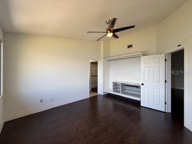 unfurnished bedroom featuring vaulted ceiling, ceiling fan, and dark hardwood / wood-style flooring