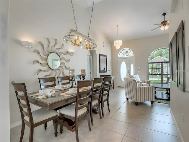 dining area with light tile patterned flooring and ceiling fan with notable chandelier