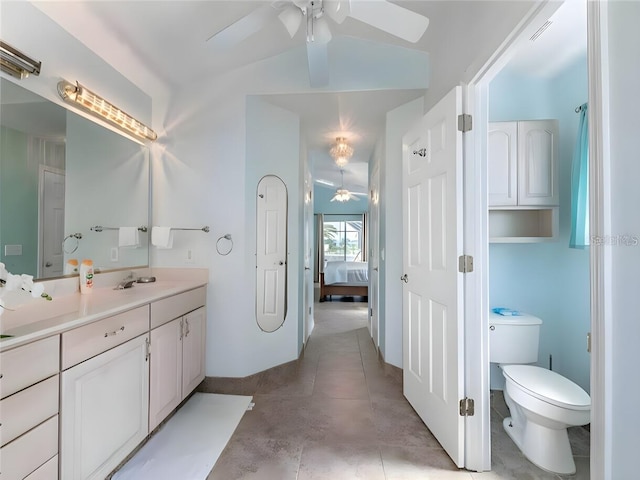 bathroom featuring tile patterned flooring, toilet, vanity, ceiling fan, and vaulted ceiling