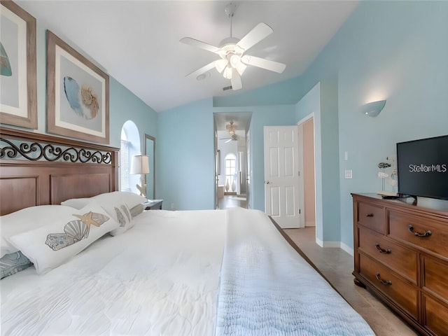 tiled bedroom with multiple windows, ceiling fan, and vaulted ceiling