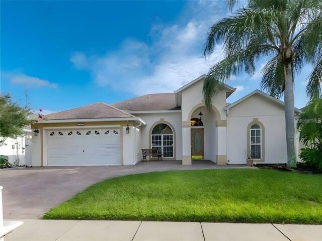 view of front of house with a garage and a front lawn