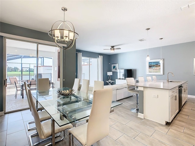 dining room featuring sink, ceiling fan with notable chandelier, and light tile patterned floors