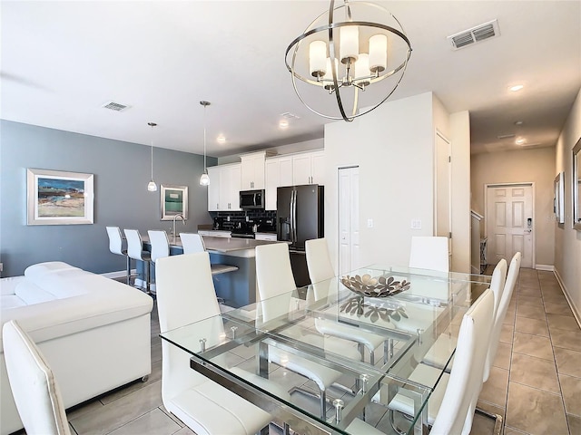 tiled dining room featuring a chandelier