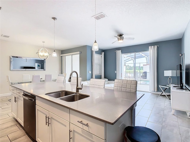 kitchen with stainless steel dishwasher, ceiling fan, white cabinets, sink, and a center island with sink