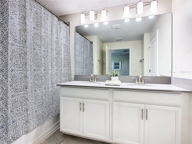 bathroom with tile patterned flooring and dual vanity