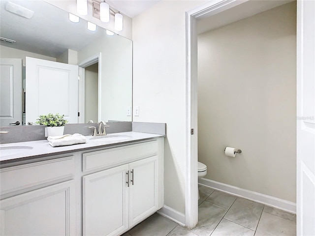 bathroom featuring tile patterned floors, double vanity, and toilet