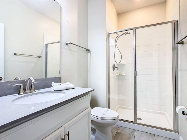 bathroom featuring tile patterned flooring, a shower with shower door, toilet, and vanity