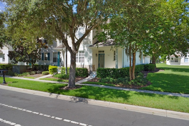 view of property hidden behind natural elements featuring a front yard