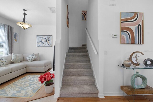 staircase with hardwood / wood-style floors