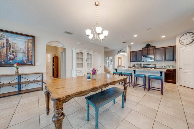 tiled dining space with an inviting chandelier