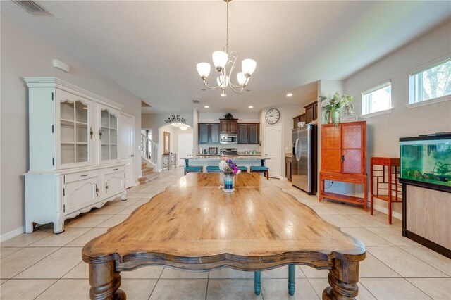 tiled dining area featuring a chandelier