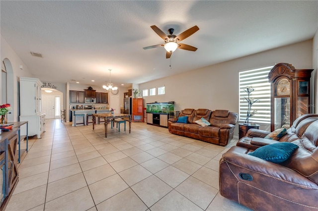 living room featuring ceiling fan with notable chandelier and light tile patterned floors