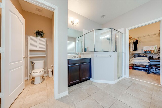 bathroom featuring vanity, an enclosed shower, tile patterned flooring, and toilet