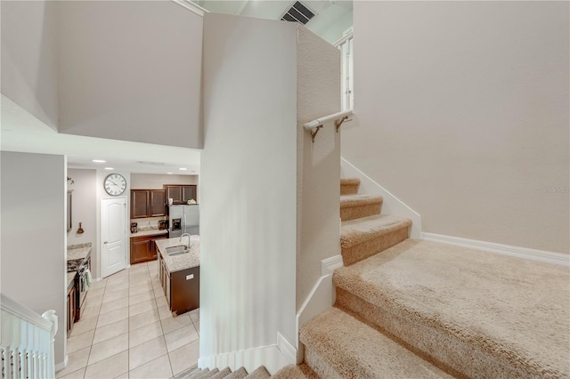 staircase featuring sink and tile patterned floors