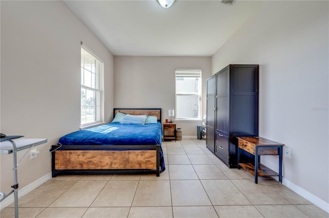 bedroom featuring multiple windows and light tile patterned flooring