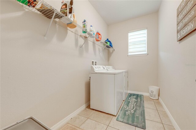 laundry area featuring light tile patterned flooring and washer and clothes dryer