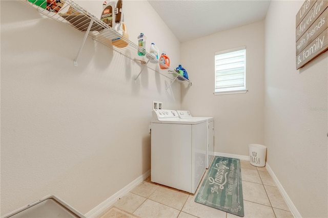 laundry room featuring washing machine and dryer and light tile patterned flooring