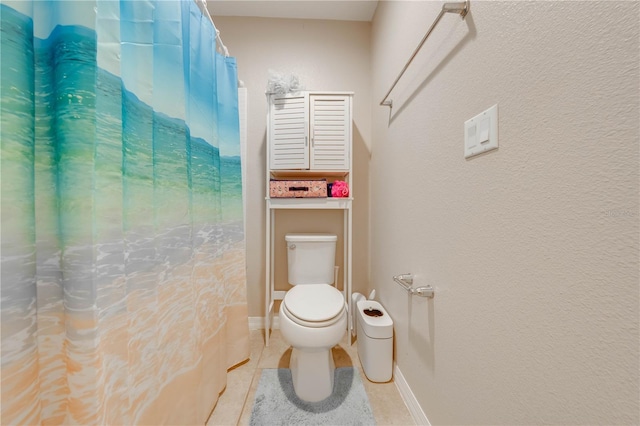 bathroom with toilet, curtained shower, and tile patterned flooring