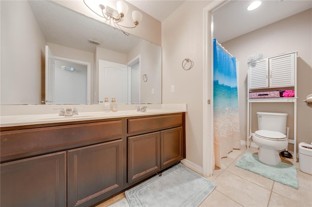 bathroom featuring toilet, a textured ceiling, tile patterned flooring, and double vanity