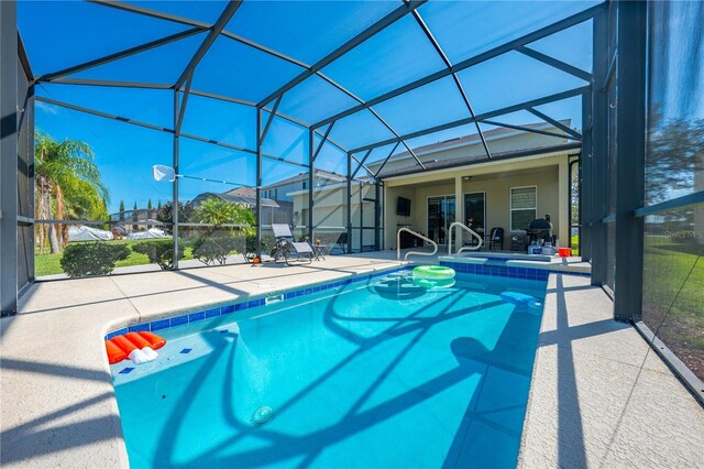 view of swimming pool with a patio area and glass enclosure