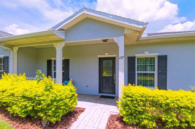 view of exterior entry with a porch