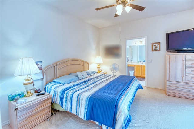 bedroom with connected bathroom, light carpet, and ceiling fan