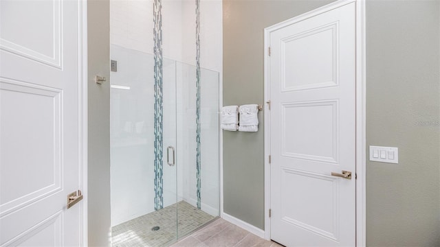 bathroom featuring a shower with door and tile patterned flooring