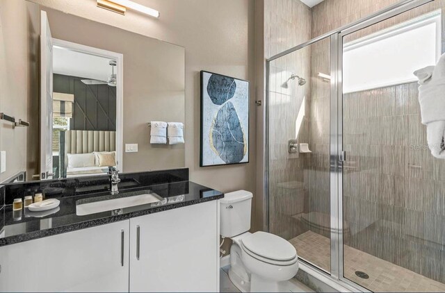 bathroom with vanity, toilet, and a shower with shower door