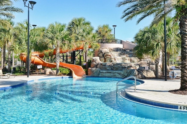 view of pool featuring a water slide and a playground