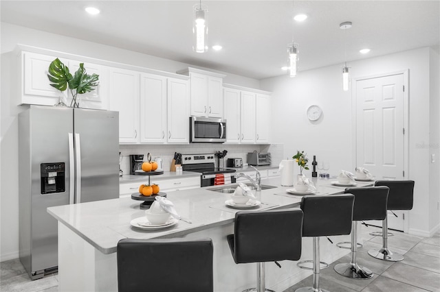 kitchen featuring sink, appliances with stainless steel finishes, decorative light fixtures, and backsplash