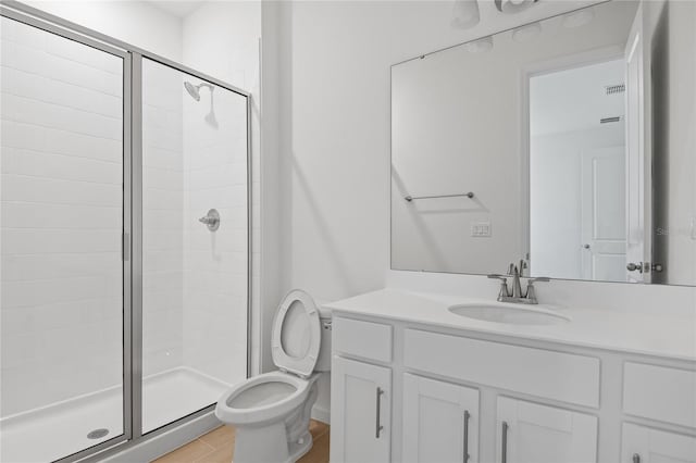 bathroom with a shower with shower door, toilet, and vanity