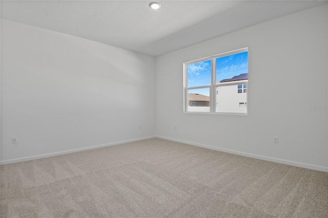 carpeted spare room with a textured ceiling