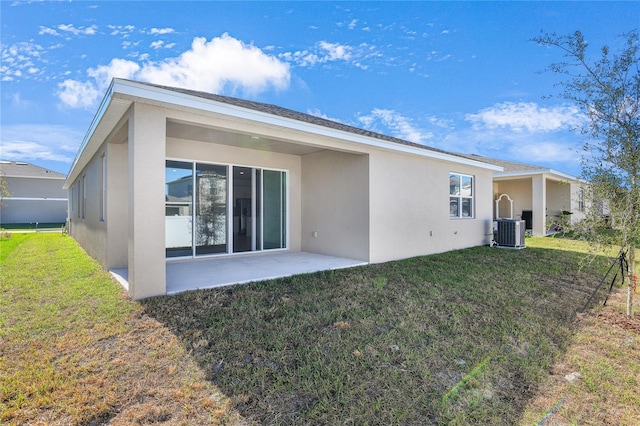 rear view of house with central AC unit, a patio area, and a lawn