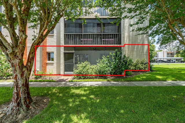 view of front of property featuring a balcony and a front lawn