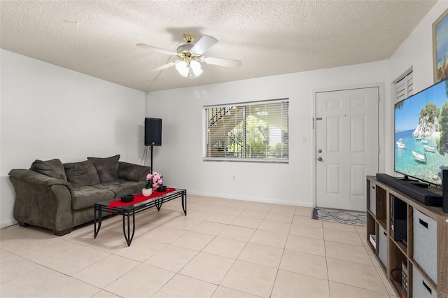 living area featuring light tile patterned flooring, a textured ceiling, and ceiling fan