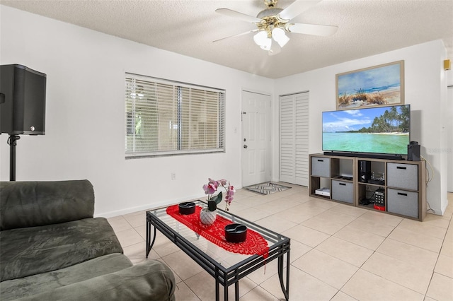 living room featuring light tile patterned floors, a textured ceiling, and ceiling fan