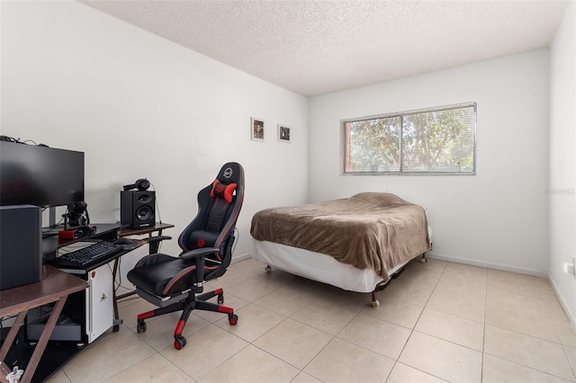 bedroom with light tile patterned floors, baseboards, and a textured ceiling