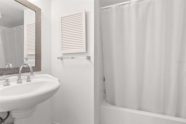 bathroom featuring a sink and shower / bath combo with shower curtain