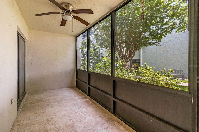 unfurnished sunroom featuring ceiling fan