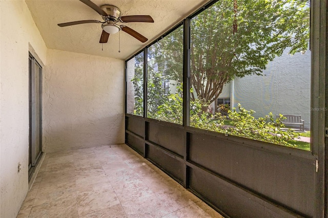 unfurnished sunroom featuring ceiling fan