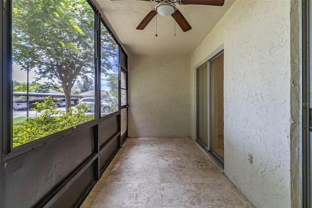 unfurnished sunroom featuring ceiling fan