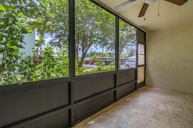 unfurnished sunroom featuring ceiling fan