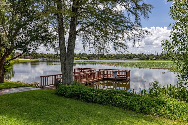 view of dock featuring a water view and a yard