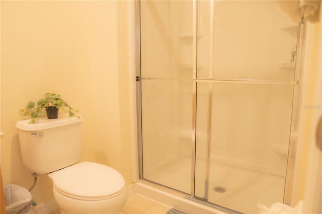 bathroom with a shower with shower door, toilet, and tile patterned floors