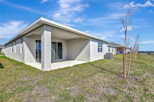 back of property with a patio, cooling unit, and a lawn