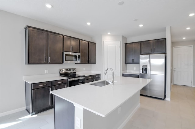 kitchen featuring appliances with stainless steel finishes, sink, a kitchen island with sink, and dark brown cabinets