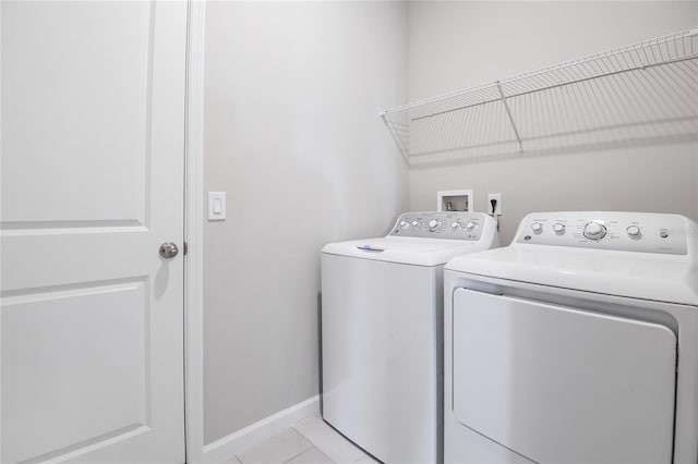 clothes washing area featuring separate washer and dryer and light tile patterned floors