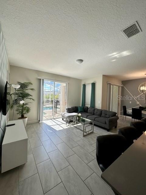 living room with a textured ceiling and light tile patterned floors